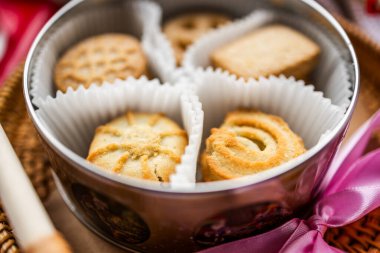 Danish shortbread cookies on a white towel, boiled condensed milk in a glass milk jug, light still life, wheat ears, tea with cookies