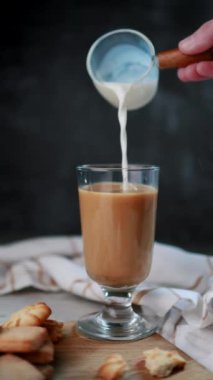 Büyük bir bardak kahveye süt döken kadın, köy usulü, kurabiyeler, siyah arka plan, kahve, sütlü kahve