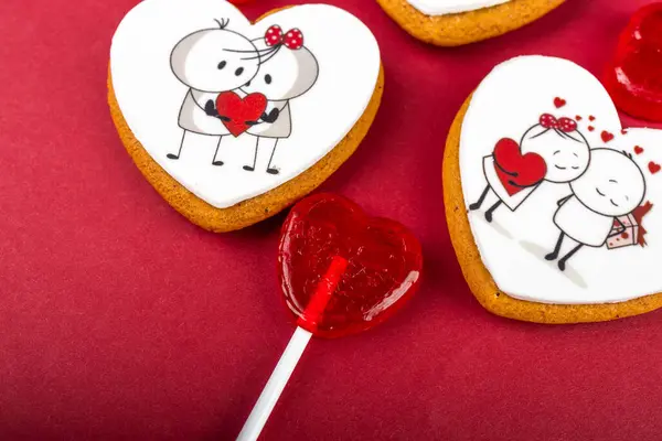 kalp şeklinde kurabiyeler kırmızı kalpler ve beyaz arka planda şekerler