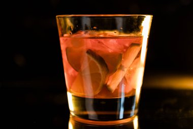 Siyah ayna arka planında buzlu ve limonlu viski, içki, alkol, alkollü kokteyller, nefis bir viski kokteyli.