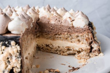 Fındıklı Kyiv keki, beyaz bir tabakta beyaz bir kek tepsisinde krema, espresso kahvesi, altın çatal bıçak takımı, Ukrayna tatlıları, fındıklı kek, flatlay