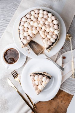 Fındıklı Kyiv keki, beyaz bir tabakta beyaz bir kek tepsisinde krema, espresso kahvesi, altın çatal bıçak takımı, Ukrayna tatlıları, fındıklı kek, flatlay
