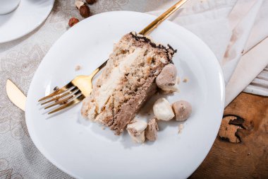 Fındıklı Kyiv keki, beyaz bir tabakta beyaz bir kek tepsisinde krema, espresso kahvesi, altın çatal bıçak takımı, Ukrayna tatlıları, fındıklı kek, flatlay