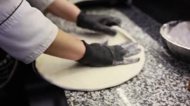 Şef mutfakta pizza hazırlıyor.