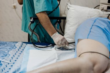 Kolonoskopi yapan endoskopist, kolonoskopi için endoskop, bağırsak incelemesi, gastroskopi, hastane, kanepede yatan hasta, kanser önleme, ameliyat odası, endoskopiyle muayene.