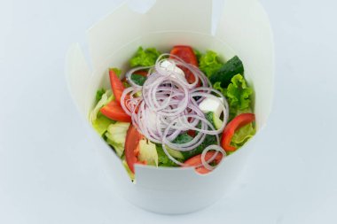 Sebzeli bir tabak salata ve cam bardak.