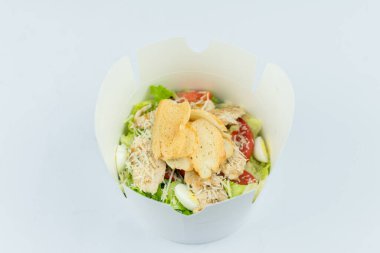 Restoranda beyaz bir arka planda salatalı tavuk.