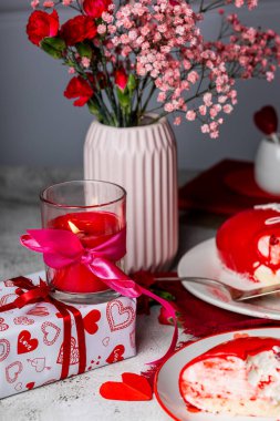 Sevgililer Günü geçmişi, kalpler, mumlar ve güller ahşap masada.