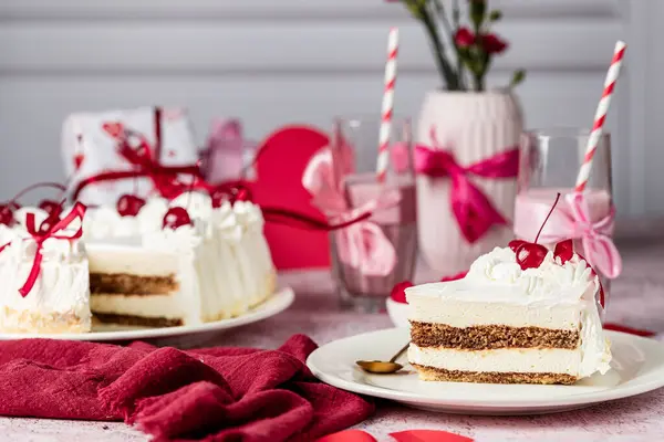 Beyaz bir tabakta beyaz kremalı kalp şeklinde tiramisu pastası, kokteyl kirazı, kırmızı kurdele, Sevgililer Günü pastası, vişneli tiramisu, kremalı pasta, doğum günü tatlıları.