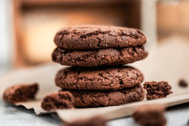 Amerikan çikolatalı kurabiyeleri kahve, el yapımı kurabiyeler, ev yapımı pişirme, kraft kağıdı, kurabiye paketleme, makro kurabiye dokusu, sıcak ışık kompozisyonu, seçilmiş odak, natürmort, yemek fotoğrafçılığı.