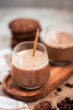 Sıcak çikolata ya da bir fincan kakao, beyaz bir masada çikolata ve tarçınlı, yakın plan.