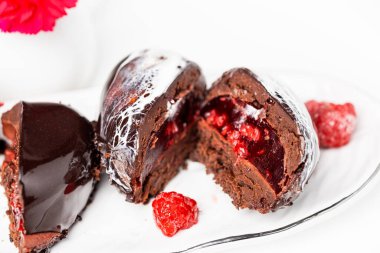 Beyaz tabakta ahududulu çikolatalı kek.