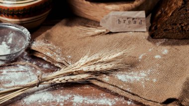 Un, buğday kulakları ve tahta kaşık. ahşap bir arka planda.