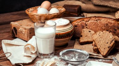 Ahşap zemin üzerinde ekmek ve süt içeren kompozisyon