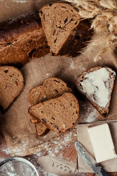 Tahta bir masada tereyağı ve tohumla ev yapımı doğal ekmek.