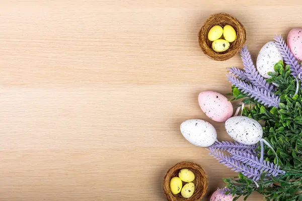 Ahşap arka planda paskalya yumurtaları, üst görünüm, düz görünüm, yuvada boyanmış bıldırcın yumurtaları, metin, kopya alanı, Paskalya konsepti.