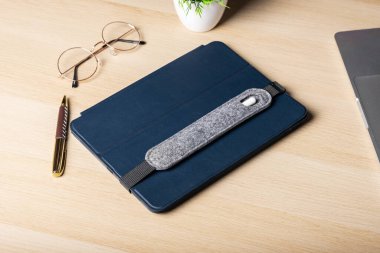 Stylus için el yapımı gri kutu mavi kutuda, tablette yatıyor. Stylus ve tablet açık tahta masaüstünde. İş anlayışı, eğlence, internette sörf.