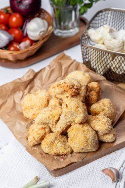 Karnabahar kızartması bir çatalla dilimlenmiş, yağsız bir tabak, hamurda karnabahar. Sağlıklı fast food. Düşük kalorili yemek kızartması. Lahana, domates. Kızartma makinesi. Yüksek kalite fotoğraf.