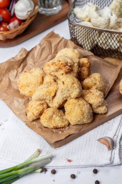 Karnabahar kızartması bir çatalla dilimlenmiş, yağsız bir tabak, hamurda karnabahar. Sağlıklı fast food. Düşük kalorili yemek kızartması. Lahana, domates. Kızartma makinesi. Yüksek kalite fotoğraf.