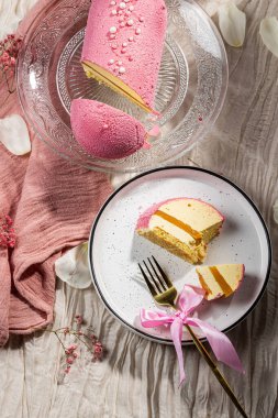 Pembe kadifeli kremalı pasta, mango kreması ve cam kek tabağındaki bir kesikte tutku meyvesi. Düşük kalorili kremalı tatlı. Mangolu kek ve tutku meyvesi. Yan görüş. Flatlay. Yüksek kalite fotoğraf