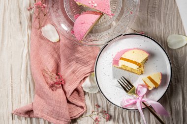 Pembe kadifeli kremalı pasta, mango kreması ve cam kek tabağındaki bir kesikte tutku meyvesi. Düşük kalorili kremalı tatlı. Mangolu kek ve tutku meyvesi. Yan görüş. Flatlay. Yüksek kalite fotoğraf