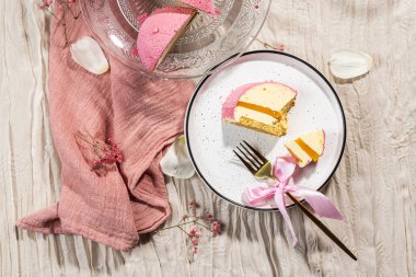 Pembe kadifeli kremalı pasta, mango kreması ve cam kek tabağındaki bir kesikte tutku meyvesi. Düşük kalorili kremalı tatlı. Mangolu kek ve tutku meyvesi. Yan görüş. Flatlay. Yüksek kalite fotoğraf