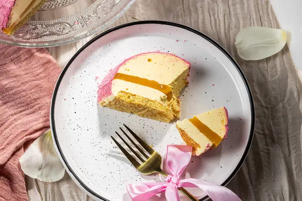 Pembe kadifeli kremalı pasta, mango kreması ve cam kek tabağındaki bir kesikte tutku meyvesi. Düşük kalorili kremalı tatlı. Mangolu kek ve tutku meyvesi. Yan görüş. Flatlay. Yüksek kalite fotoğraf