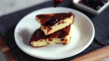 Kuru üzümlü peynirli güveç ve beyaz tabakta altın kabuklu reçel..