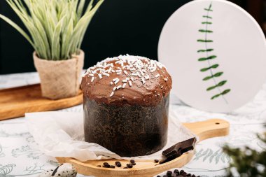 Paskalya pastası, arka planda çikolata jöleli Paskalya ekmeği, çiçekler, çikolata, çikolata damlaları. Paskalya konsepti