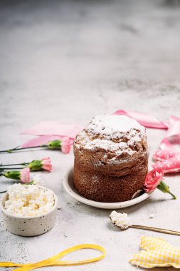 Paskalya pastası, süzme peynirli Paskalya ekmeği, arka planda pudra şekeri serpiştirilmiş, Paskalya yumurtaları, sarı kurdele, paskalya bebeği tavşanı