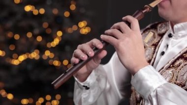 Noel zamanı peni düdüğü çalan bir adamın yakın çekimi. Bir Yıl Müzik Konsepti