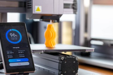Akıllı telefonda görüntülenen 3D yazıcı denetimi uygulaması. Arkaplanda, 3D yazıcı bir detay yazdırır