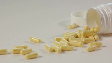 Kavanozdan sarı haplar döküldü. İlaçlarla yakın plan paketleme. B vitamini kompleksi. Sağlık, ilaç, eczane ve ilaç kavramı. Hastalıkların tedavisi ve önlenmesi.