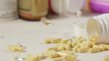 Kavanozdan sarı haplar döküldü. İlaçlarla yakın plan paketleme. B vitamini kompleksi. Sağlık, ilaç, eczane ve ilaç kavramı. Hastalıkların tedavisi ve önlenmesi.