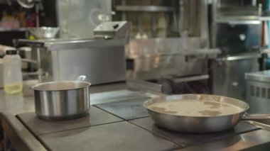 Kızartma tavası ve tencereyle ocakta yemek tabakları..