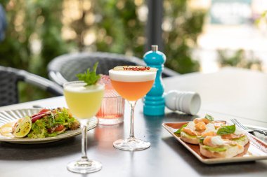 Restoranda servis edilen iştah açıcı bruschettalar ve taze içeceklerle birlikte salata.