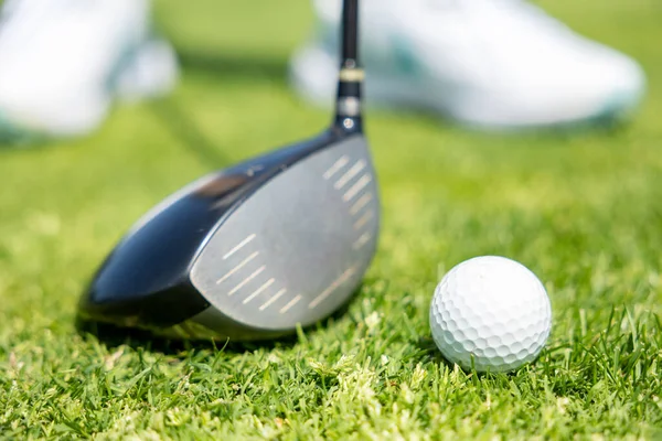 足のゴルフ選手で緑の芝生のゴルフボールにスティック — ストック写真