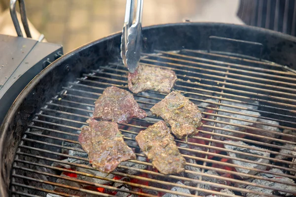肉は丸焼きにされる 肉はトングでひっくり返される 屋外ピクニック — ストック写真