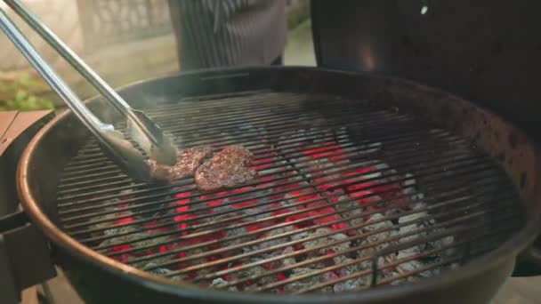 一个人的手把多汁的肉放在金属烤架上烤 放在露天篝火上做饭 夏季家庭野餐 户外食物 后续行动 — 图库视频影像