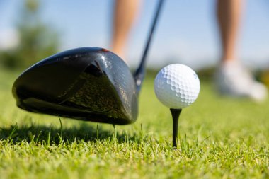Golf sopaları ve golf topları yeşil çimenli arka plan için. Çimenlikte duran topu kapat.