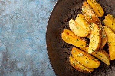 Kızarmış patates, sarımsaklı tuz biberli kimyon ve mavi gri arka planda bitki süslemesi. Üst Manzara. Boşluğu kopyala