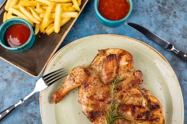 Izgara kızarmış tavuk Tabaka, patates kızartması ve mavi arka planda ketçap. Üst görünüm