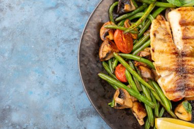 Kuşkonmaz, bezelye, sarı biber, havuç ve taze soğanlı ızgara somon. Üst görünüm, alanı kopyala
