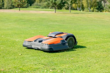 Bir robot oto biçme makinesi manikürlü çimleri keser. Golf sahasının manzara görüntüsü