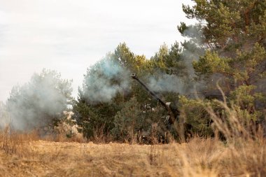 Modern Kamuflajlı Otomatik Topçu Tepesi. Savaş alanında askeri teçhizat kullanımı. Çekimden sonra. Her yerde duman var.