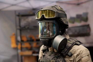Gaz maskeli manken kafası ve yeşil işaretli özel kumaştan yapılmış kimyasal koruyucu elbise. Gaz maskeli askeri manken