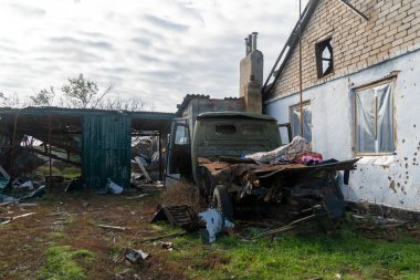 Ukrayna 'da savaş. 2022 Rus istilası Ukrayna. Kırsal kesimde. Hasarlı bir kamyon yıkılmış bir evin yanında duruyor. İnsan yok. Savaş Suçları