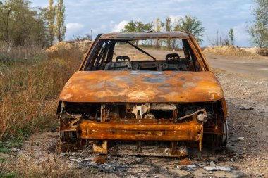Ukrayna 'da savaş. 2022 Rus istilası Ukrayna. Kırsal kesimde. Yıkılmış bir sivil araba yolun kenarında duruyor. İnsan yok. Savaş Suçları