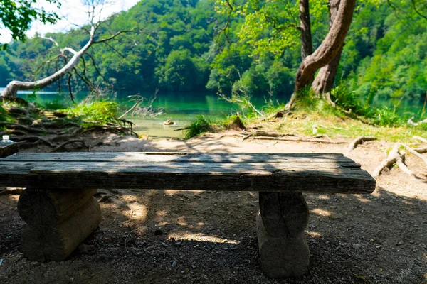 Hırvatistan. Plitvice Lakes Ulusal Parkı. Göl kıyısında turkuaz suyu olan bir bankta. Rahatlamak için bir yer. Popüler turist mekanı. UNESCO Dünya Mirasları Listesi