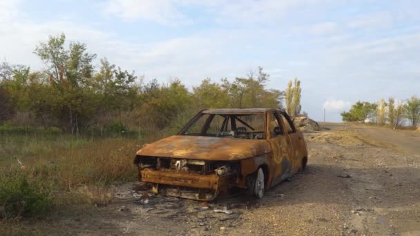 乌克兰战争 2022年俄罗斯入侵乌克兰 乡村边 路边是一辆被毁 被烧毁的民用汽车 战争罪 摄像机从左向右移动 — 图库视频影像